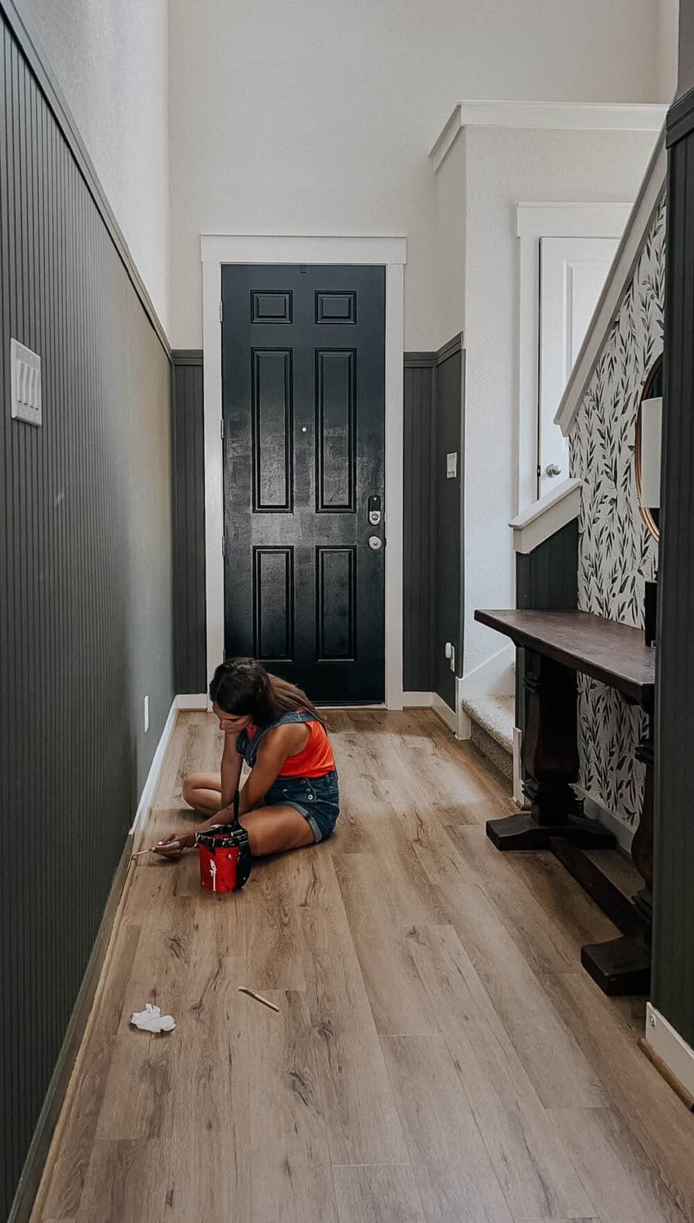 woman painting baseboards 