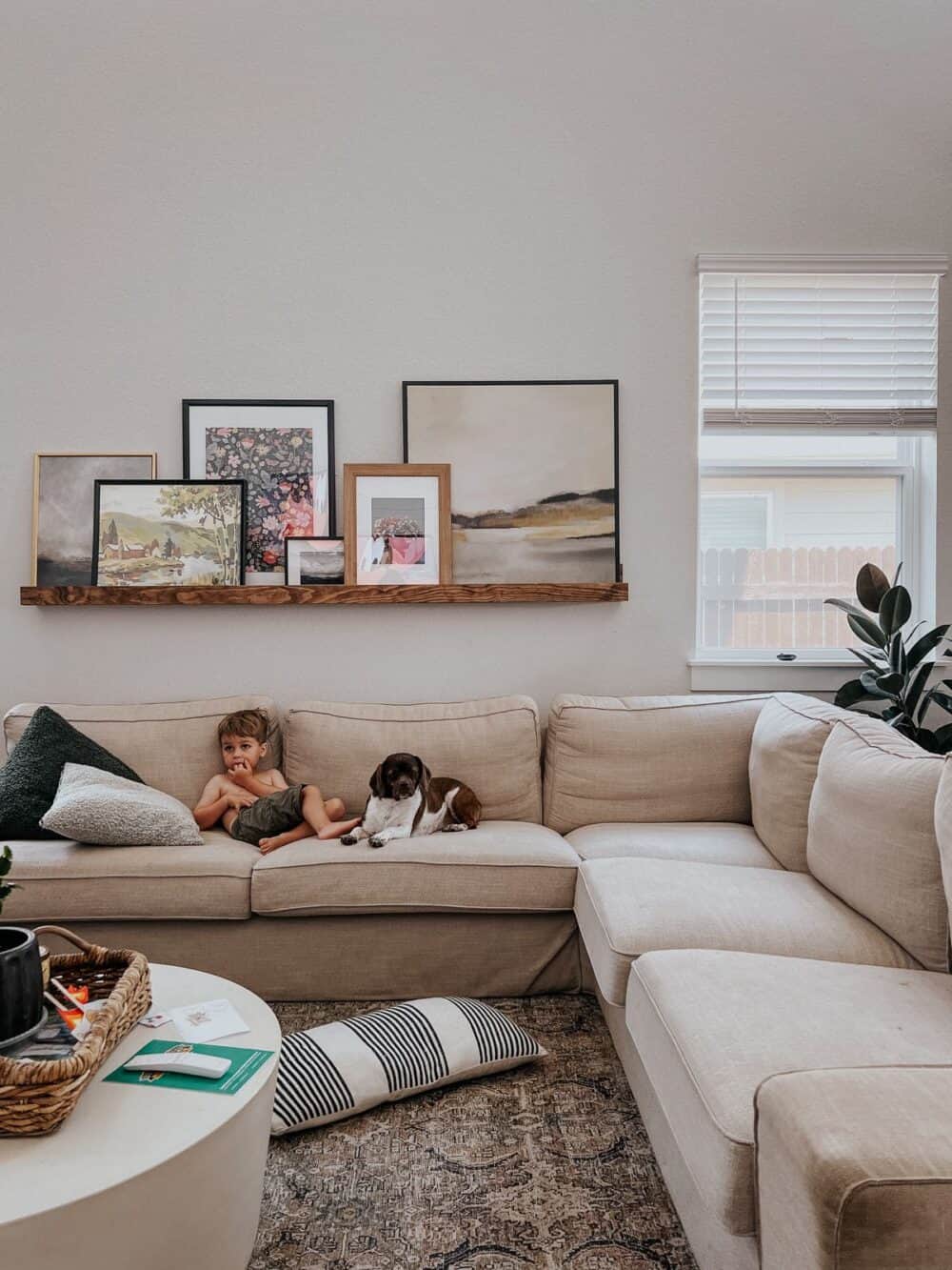 toddler lounging on a couch next to a dog