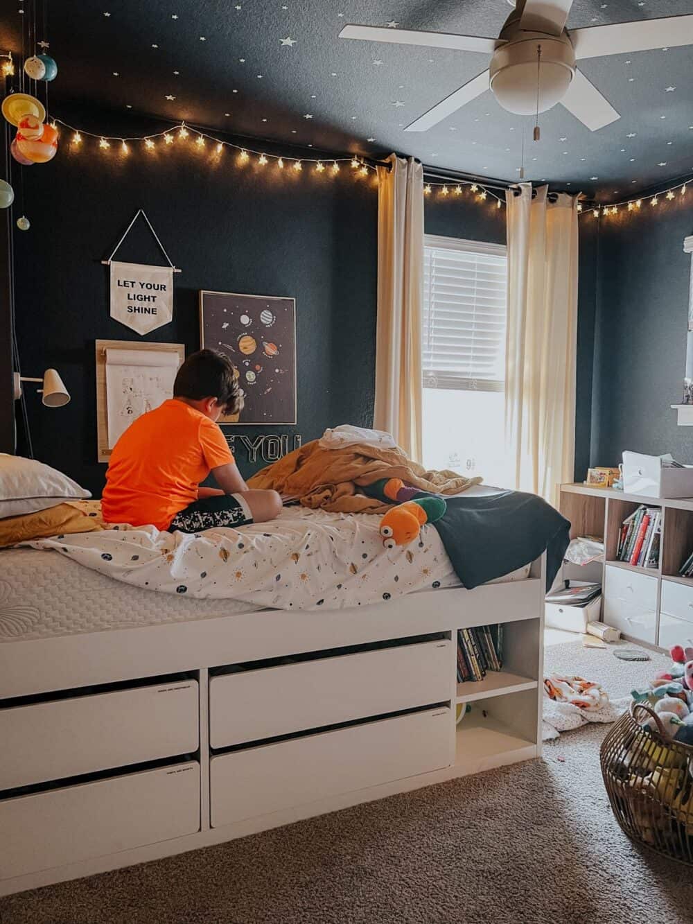 Young boy reading a book in his bed