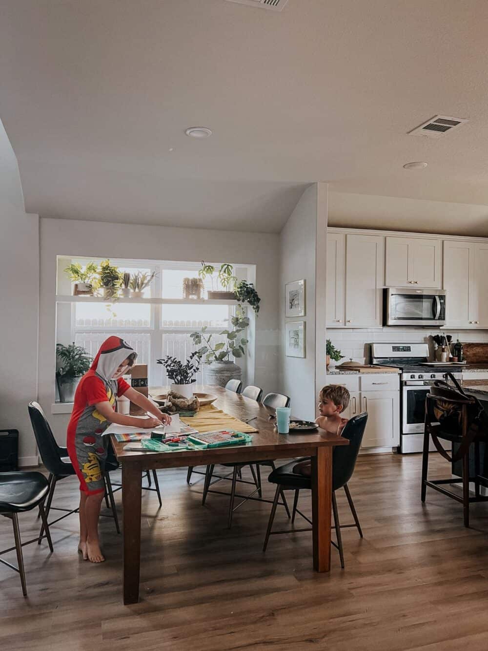 Dining room with two young boys sitting at the table.