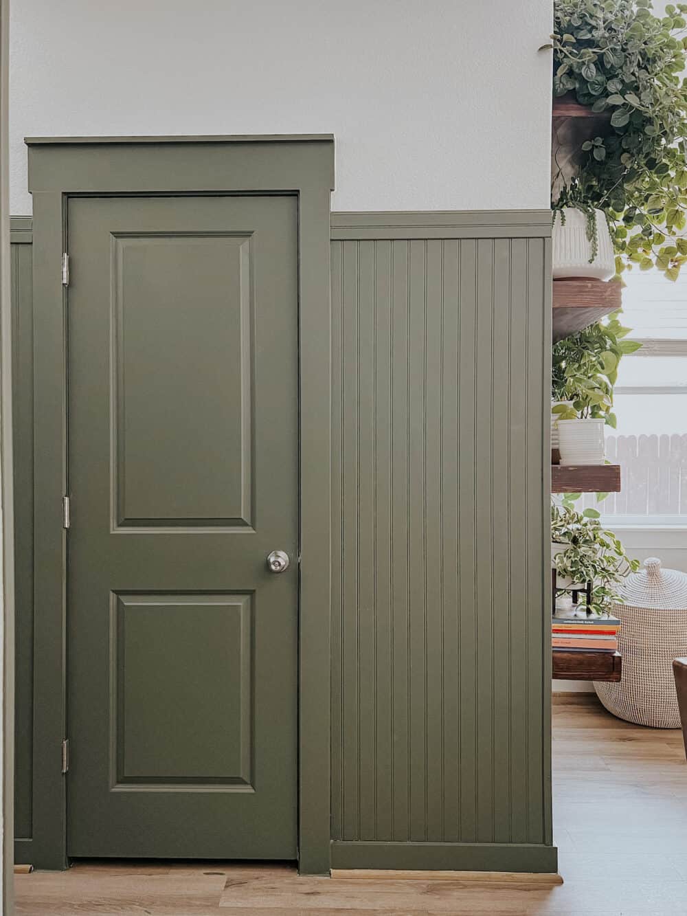 wall with beadboard and a green painted door 