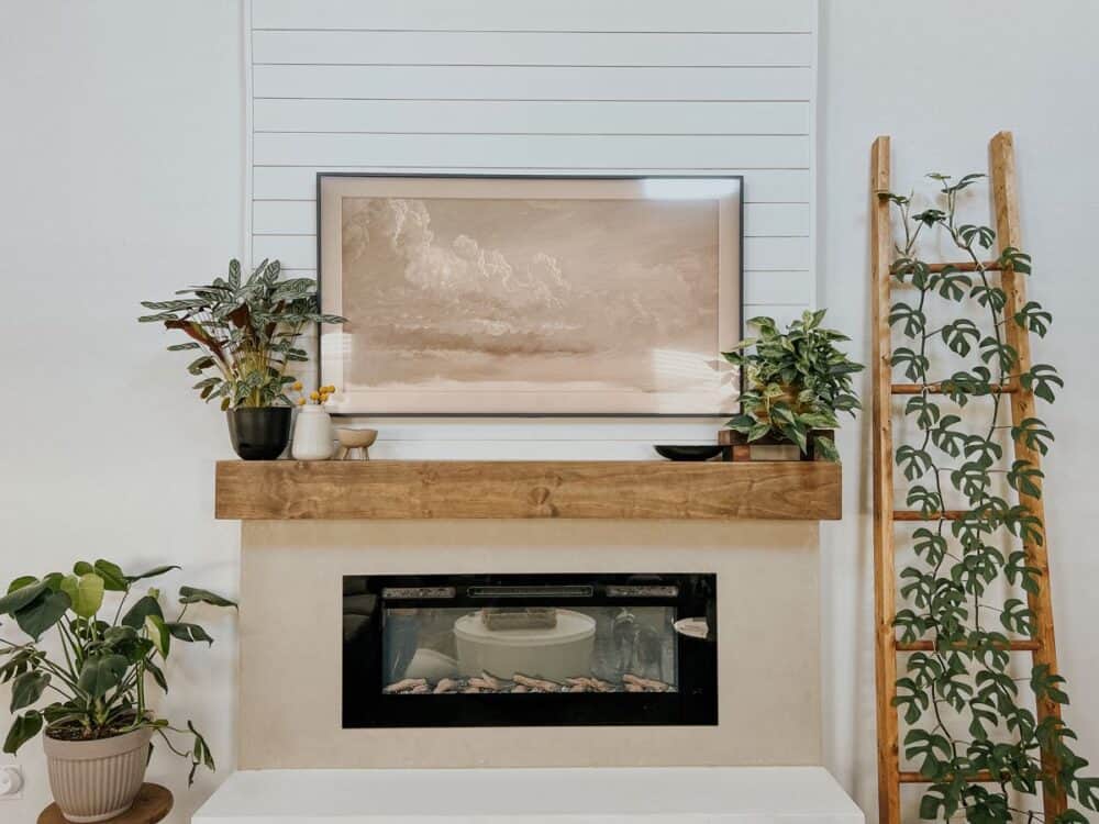 Electric fireplace with a Samsung Frame TV hanging above it 