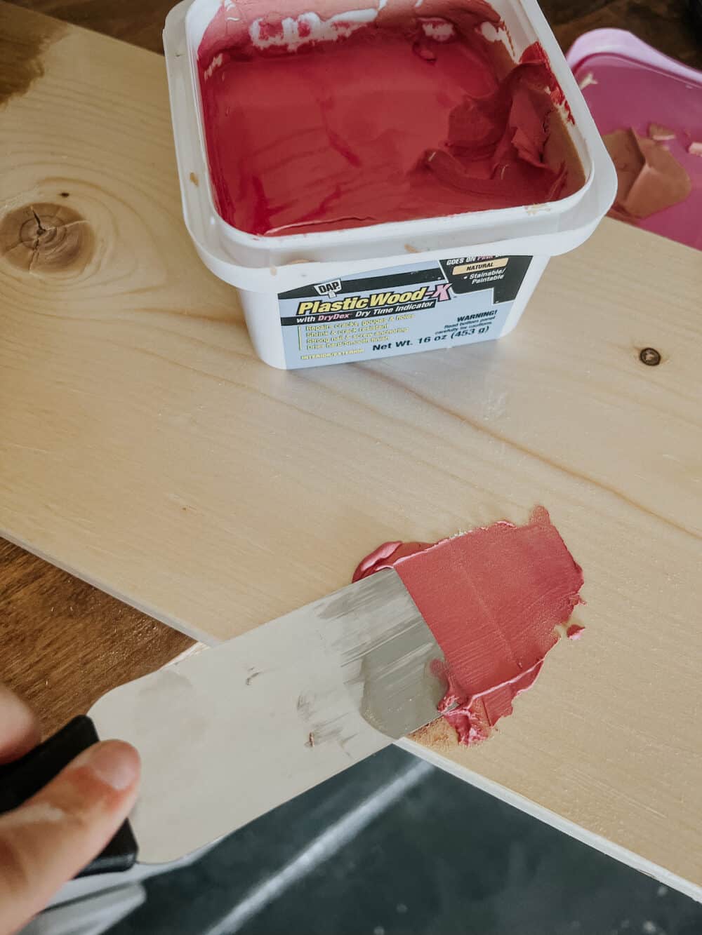 DAP plastic wood X being applied with a putty knife 