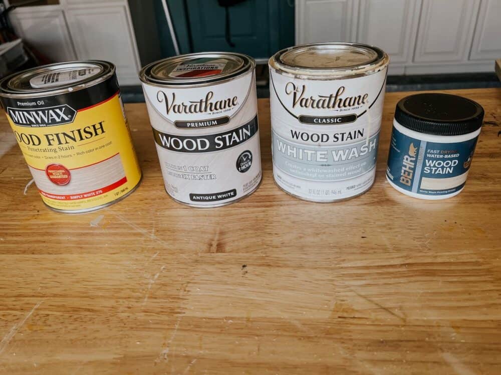 four different white wood stains on a counter 