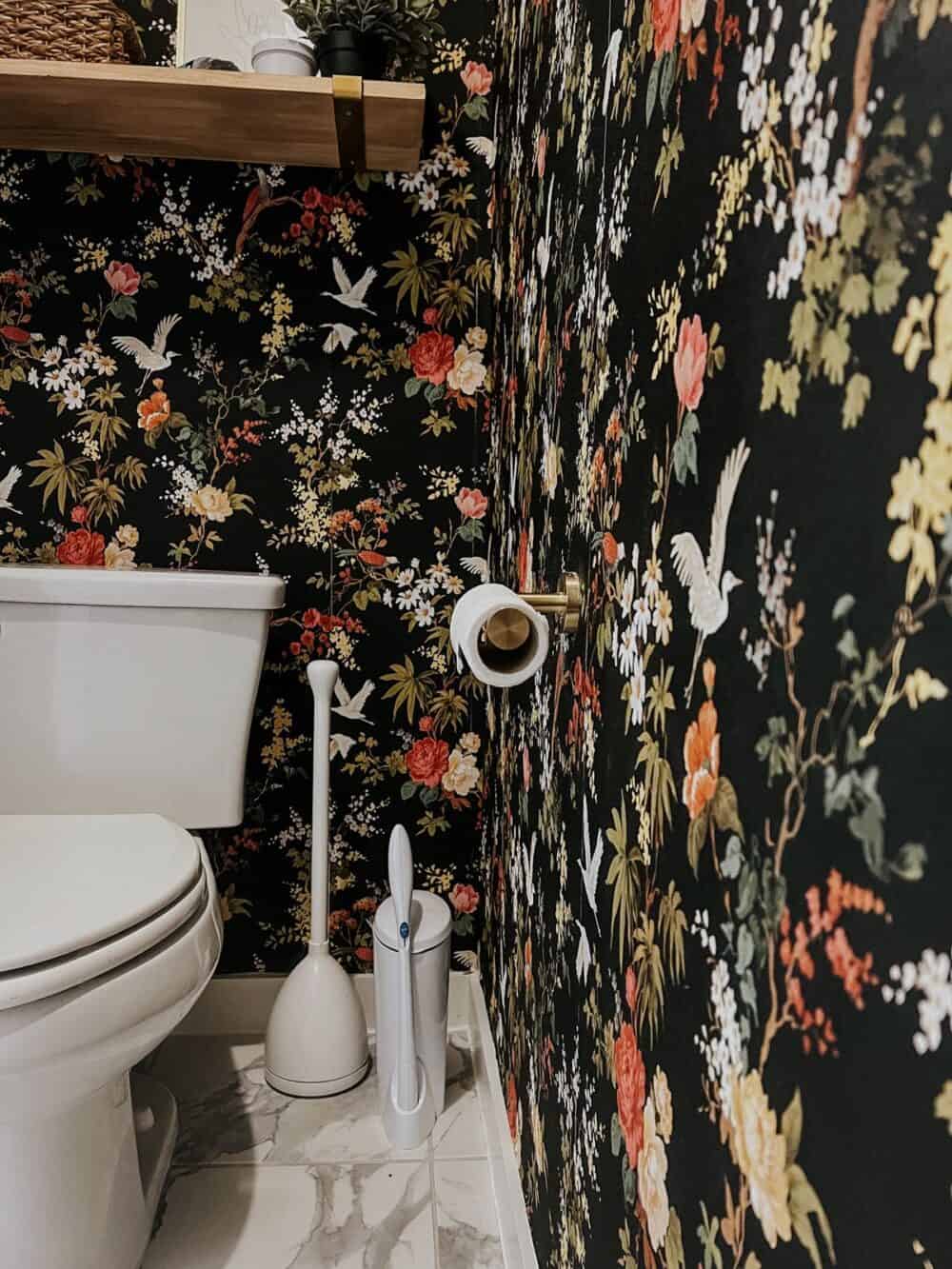 water closet with black floral wallpaper, close up of toilet cleaning tools 