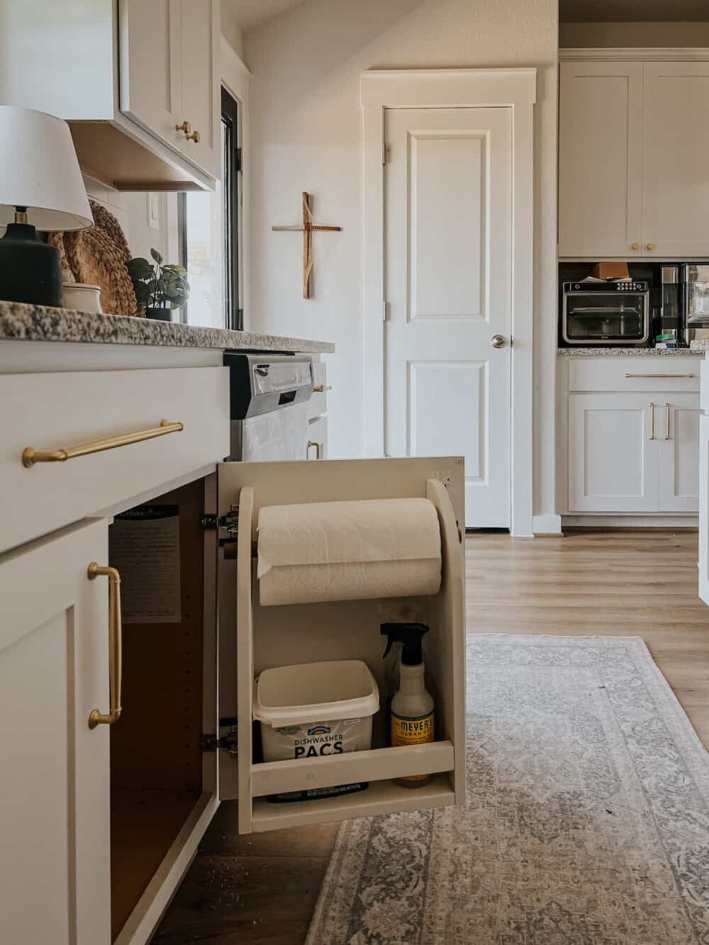 area under kitchen sink with a DIY cabinet door organizer hanging on the door 