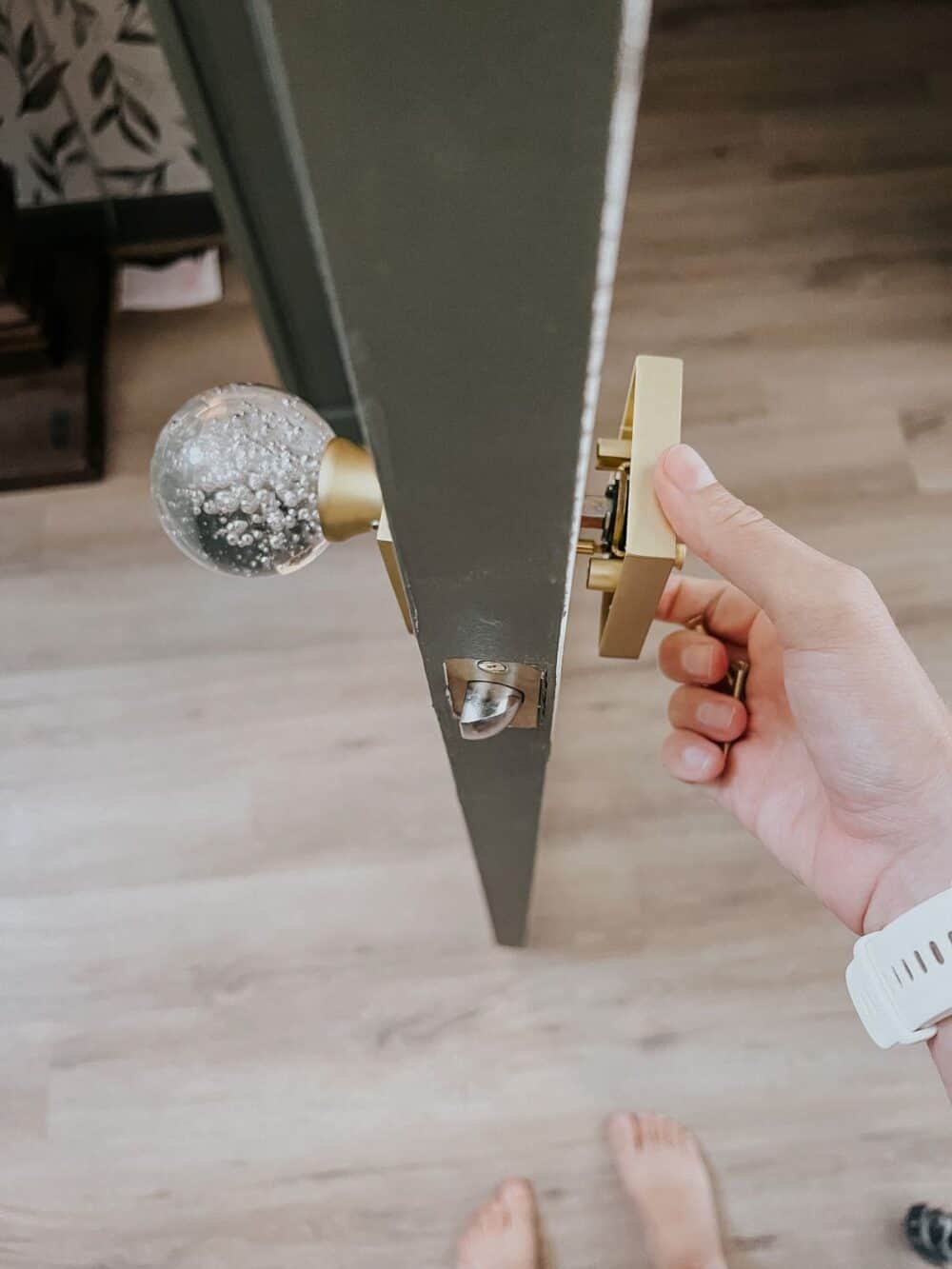 Hand assembling a new door knob on a powder room door 