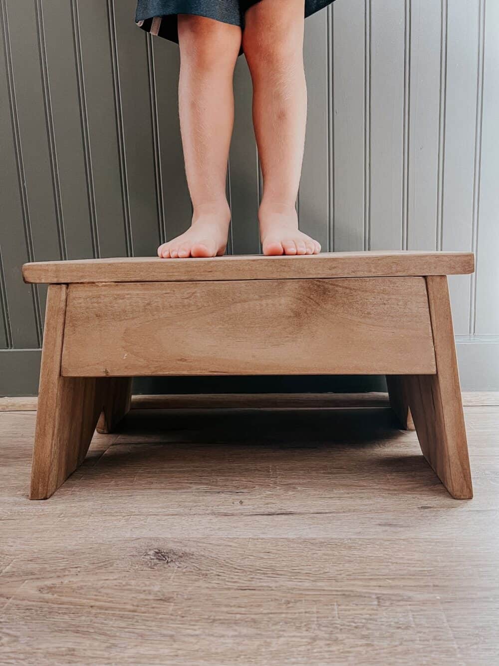 toddler feet standing on a step stool 