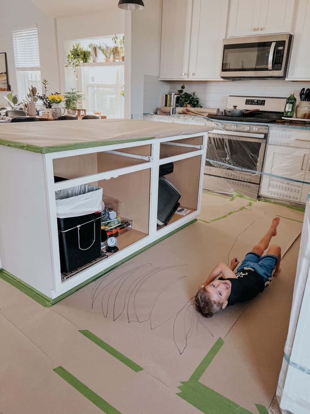 kitchen island prepped for painting with a paint sprayer 