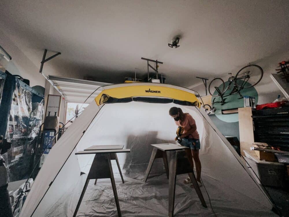 Cabinet doors being painted inside a large spray shelter 