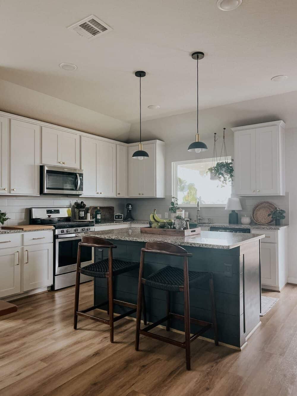 kitchen with white perimeter cabinets and a black kitchen island