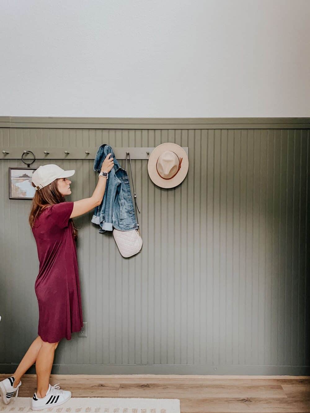 woman grabbing a jean jacket from a peg rail 