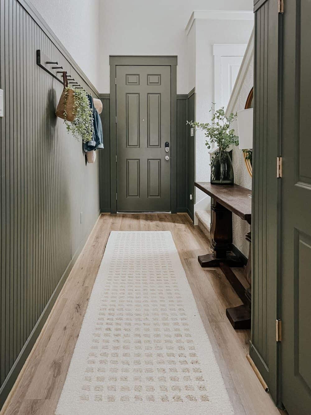 neutral entry to a home with green bead board paneling 