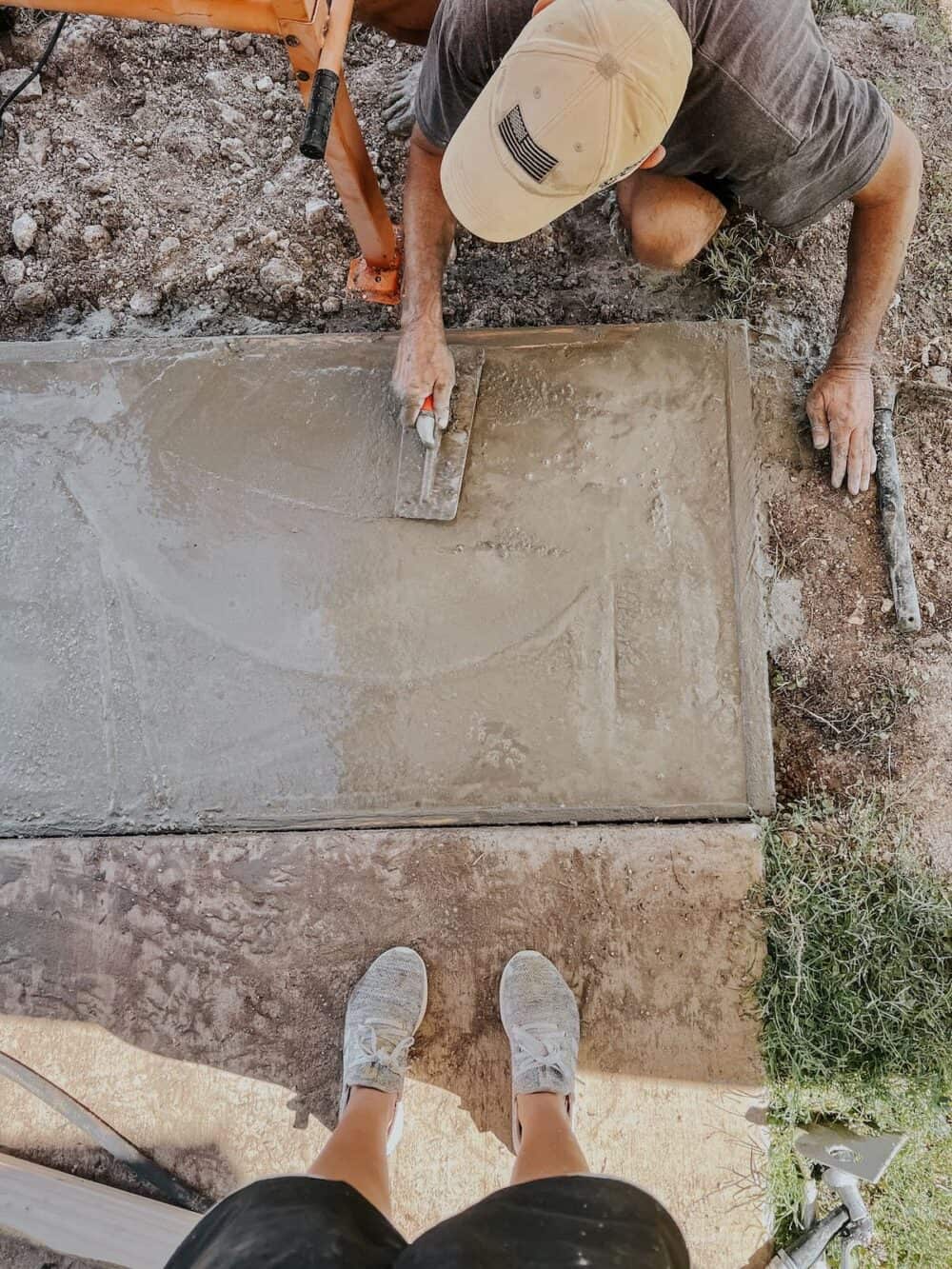 Man smoothing out DIY concrete front porch step