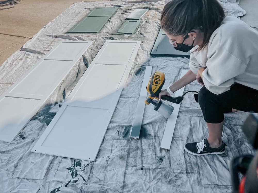 Woman using a paint sprayer to paint a piece of furniture 