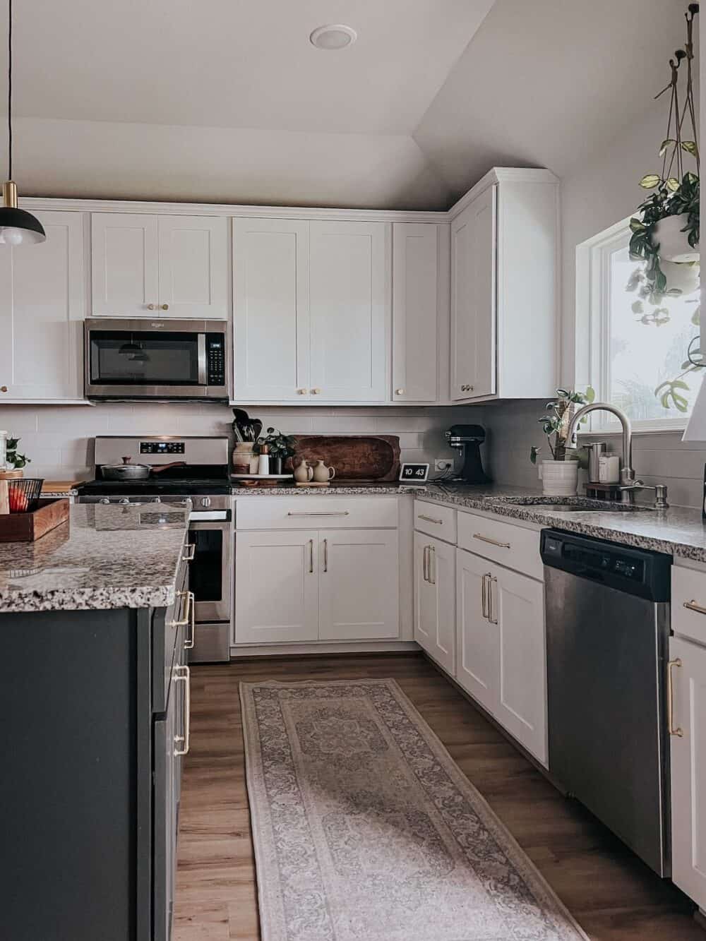 Kitchen with white perimeter cabinets and a black island