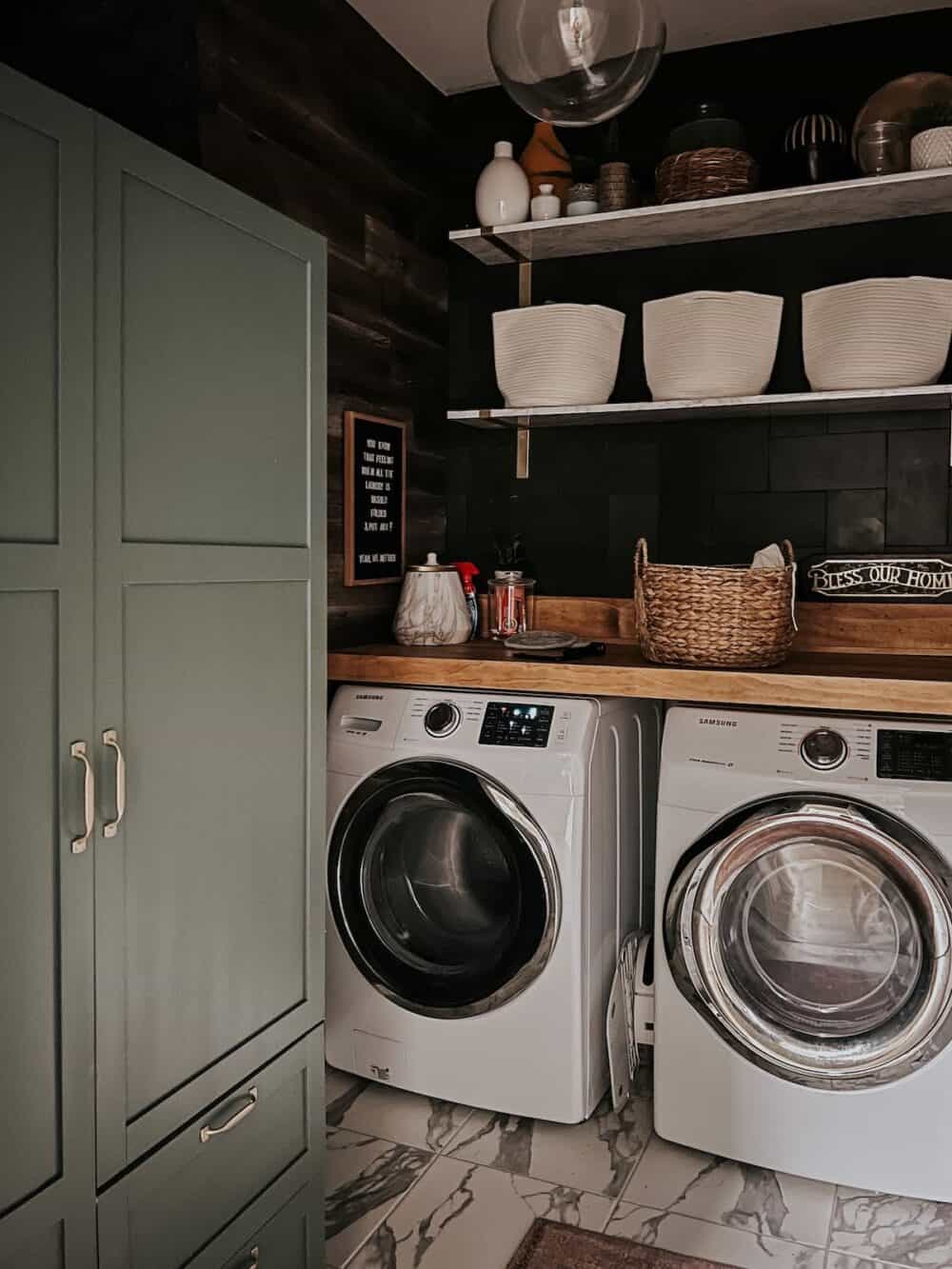 laundry room with black wall tile and a faux wood wall 