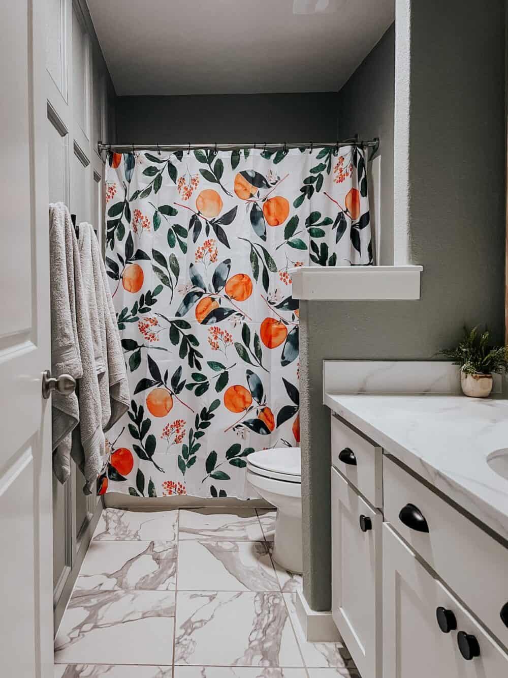 small bathroom with a trim accent wall and citrus shower curtain