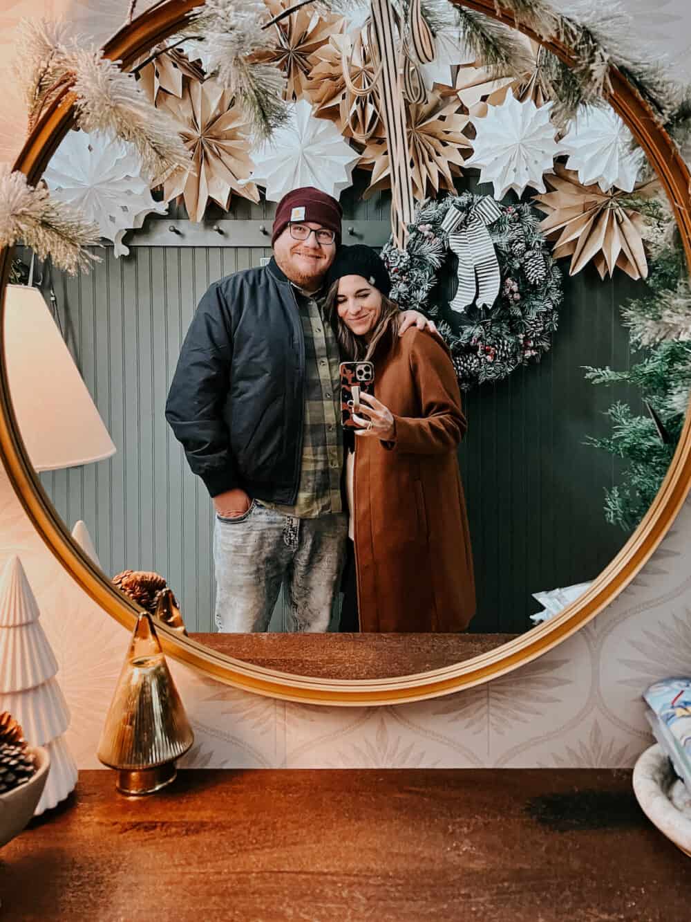 Couple posing for a photo in front of a mirror 