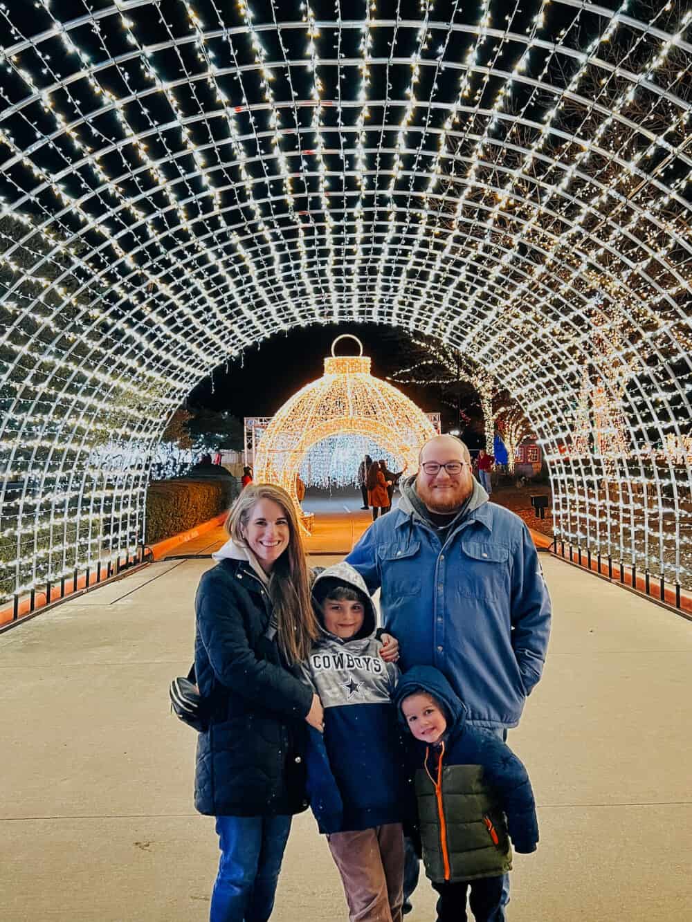 family posing in front of Christmas lights at Gaylord Texan