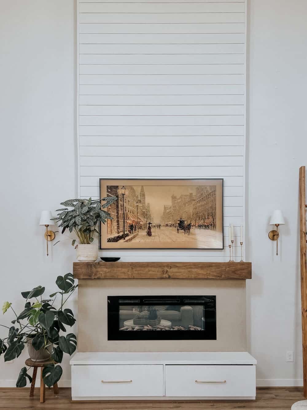 fireplace wall with two gold wall sconces flanking fireplace 