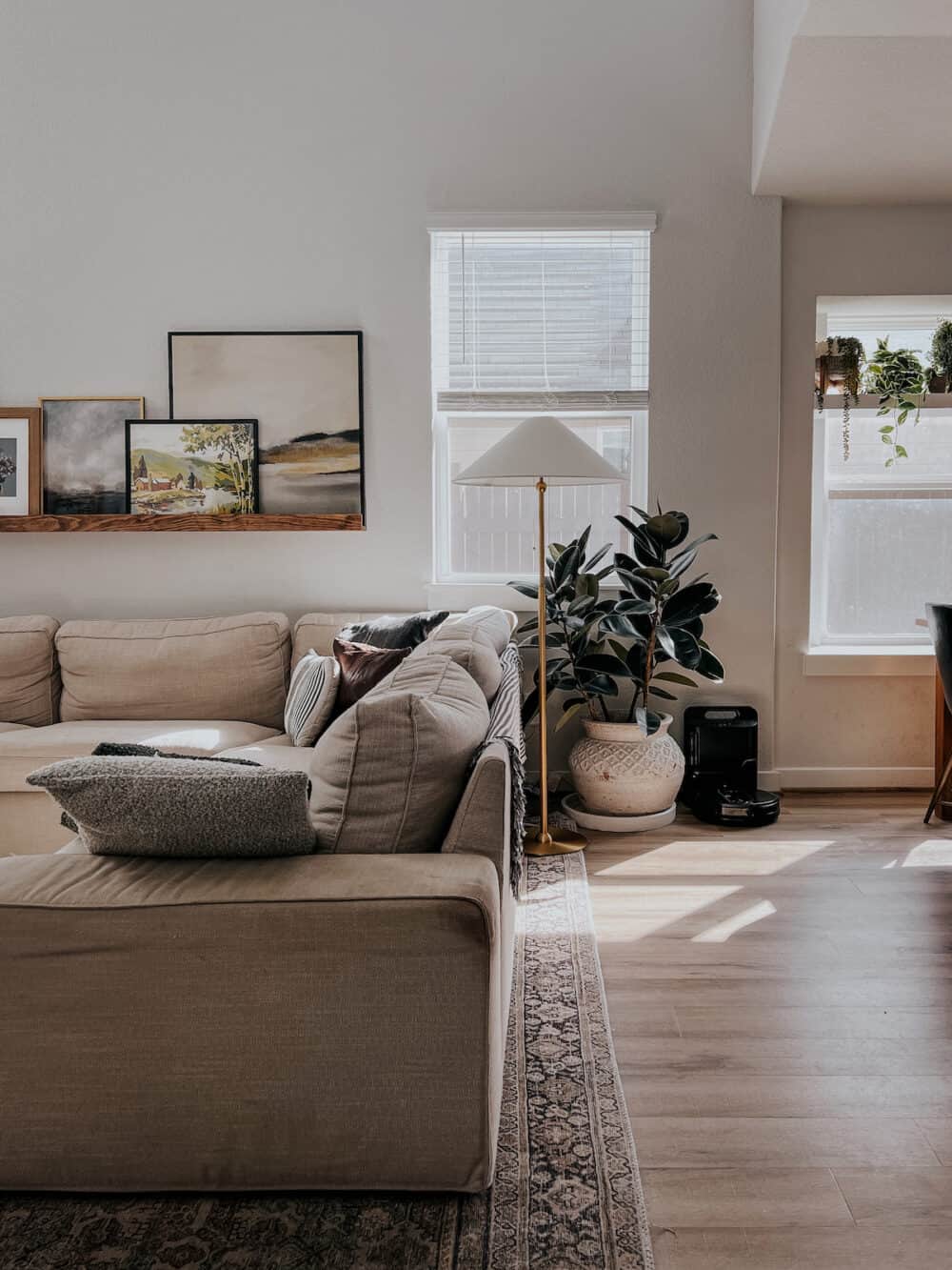 living room with a sectional and a brass floor lamp behind the sofa