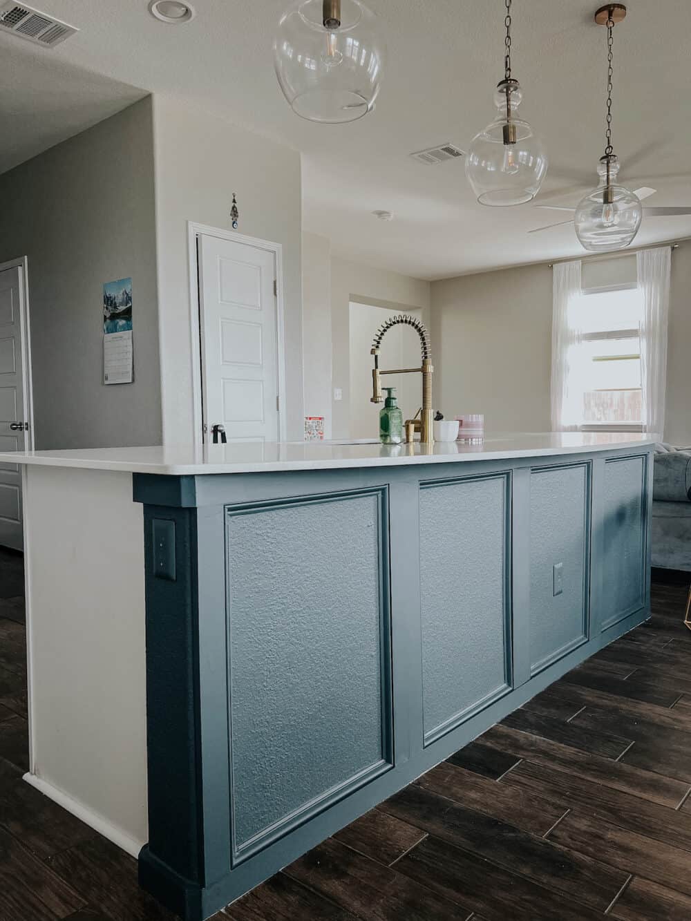 blue kitchen island with box molding on the drywall 