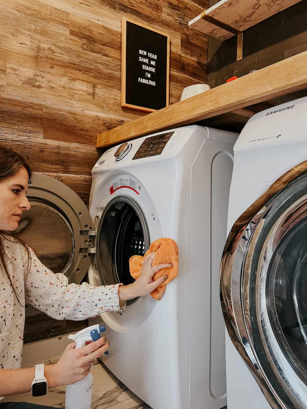 Woman wiping down the interior of a front load washer 