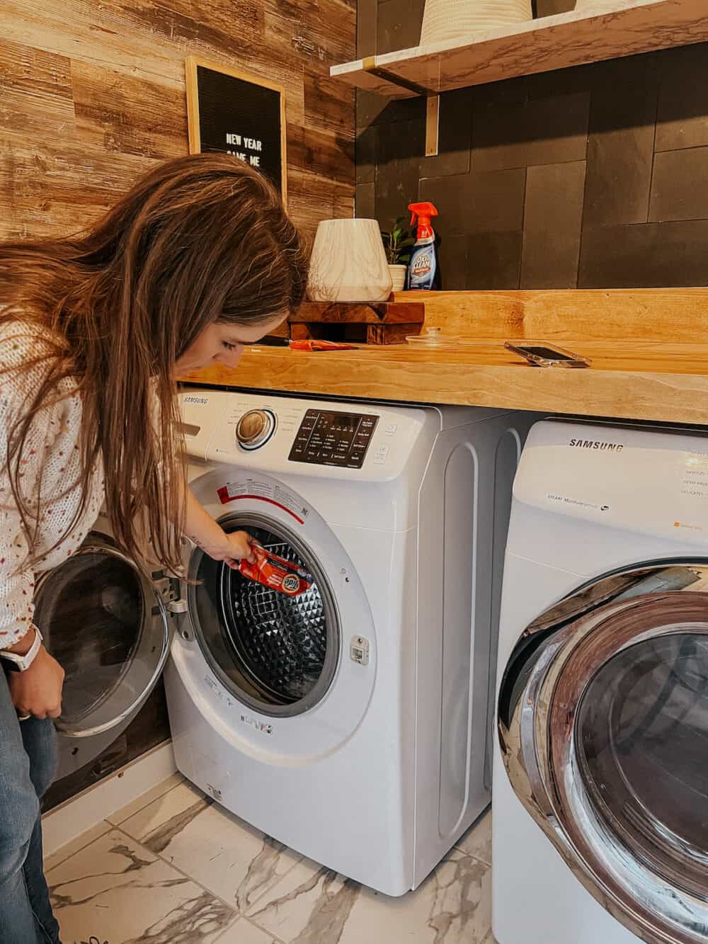 woman pouring washing machine cleaner into the tub of a washing machine 