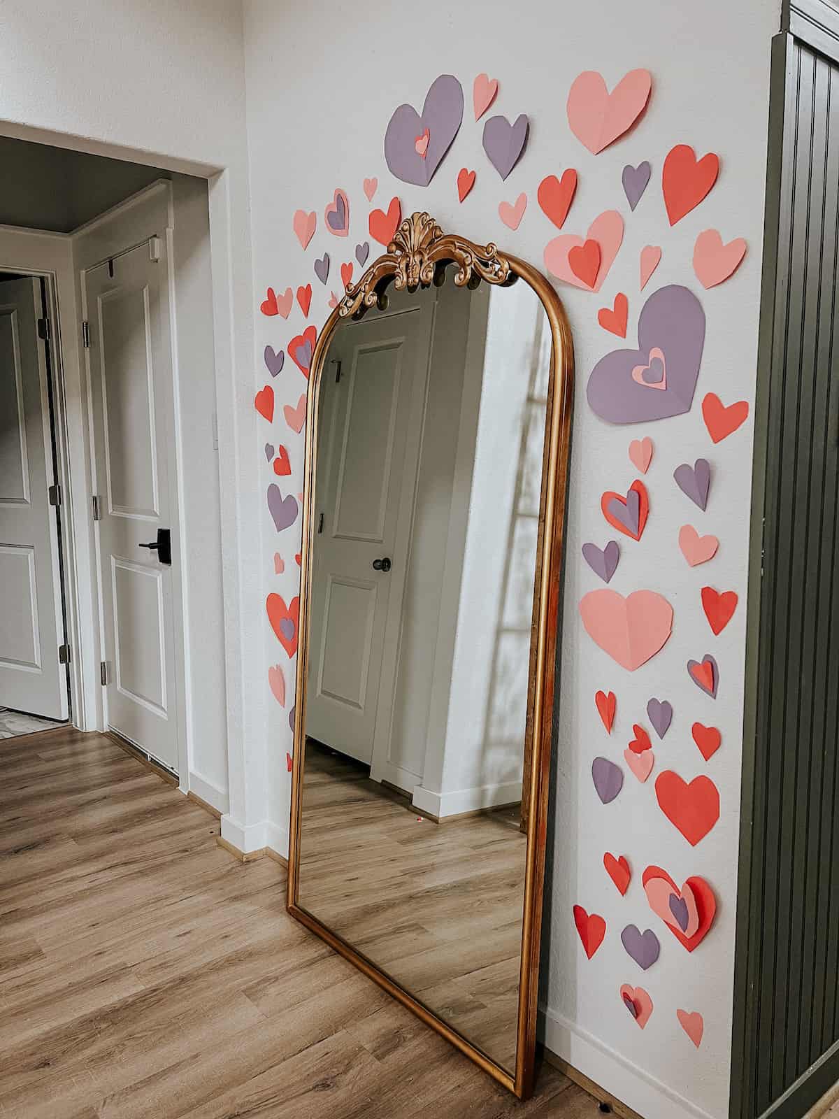 Heart collage on a wall around a mirror 