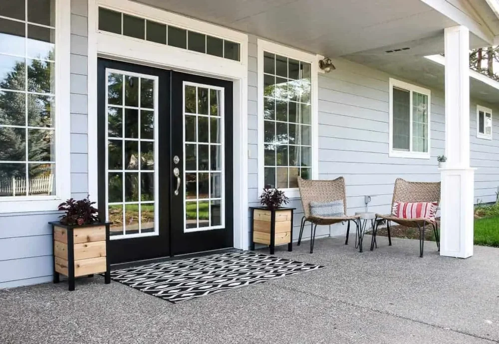 front porch with two wood and black planter boxes flanking the door 
