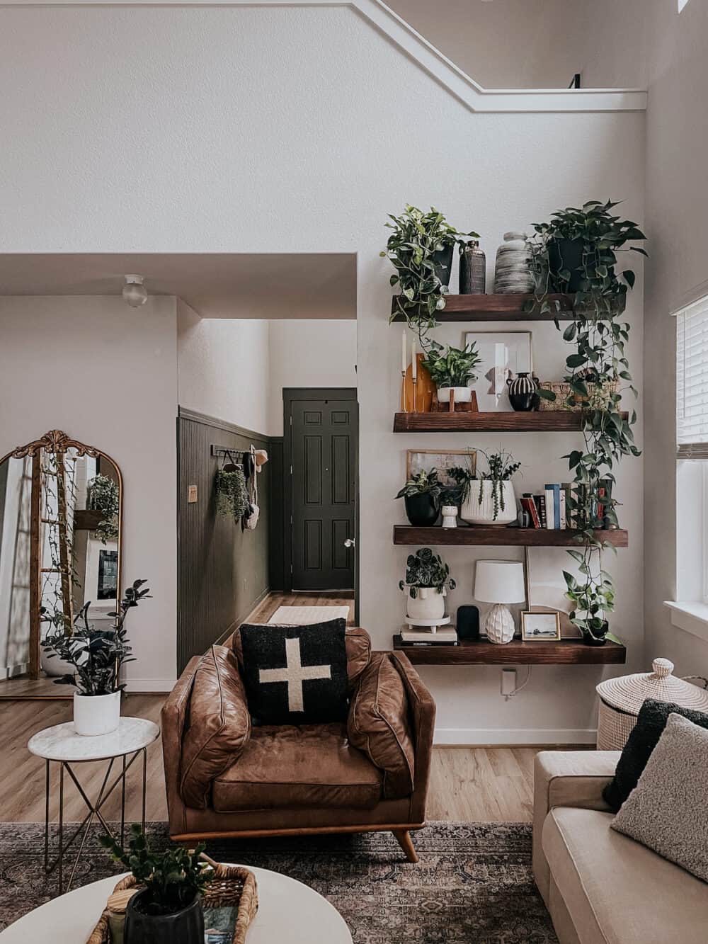 living room with a large leather chair and DIY floating shelves full of plants on the wall 