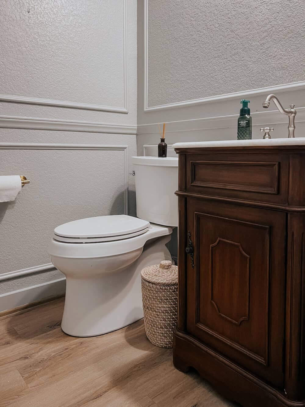 powder room with a small wood vintage style vanity