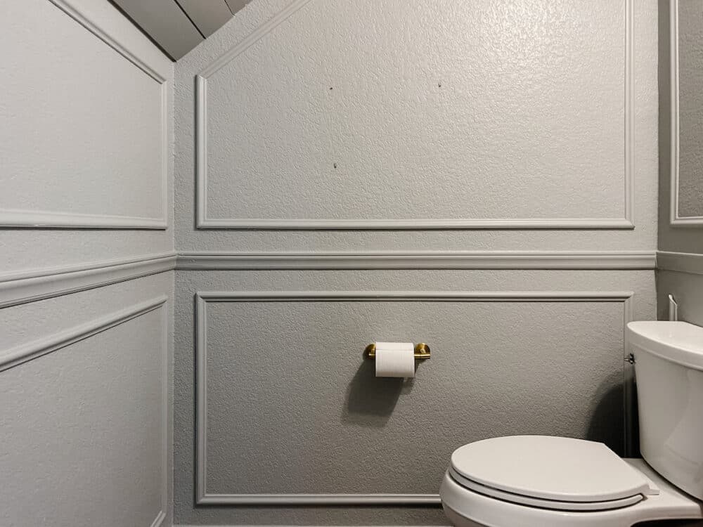 view of small powder room with picture frame molding 