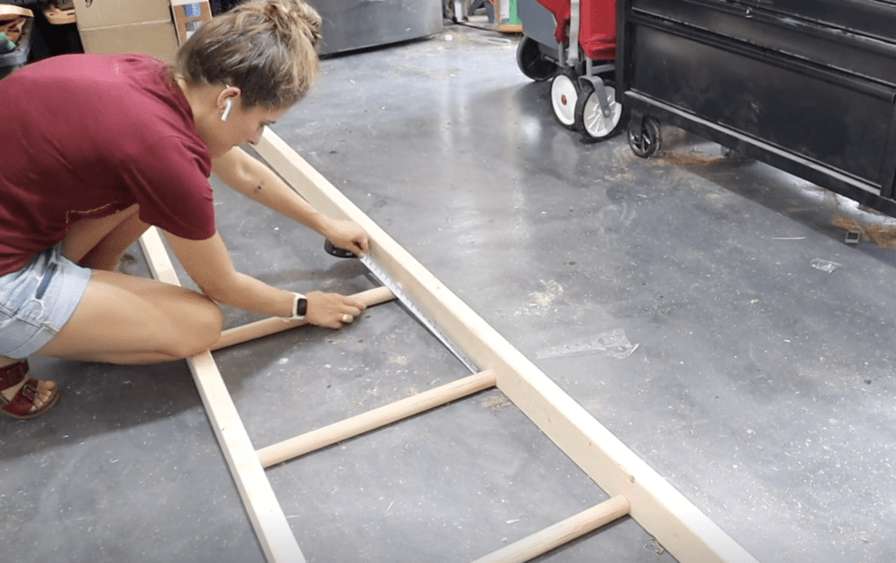 woman measuring spacing for a DIY blanket ladder 