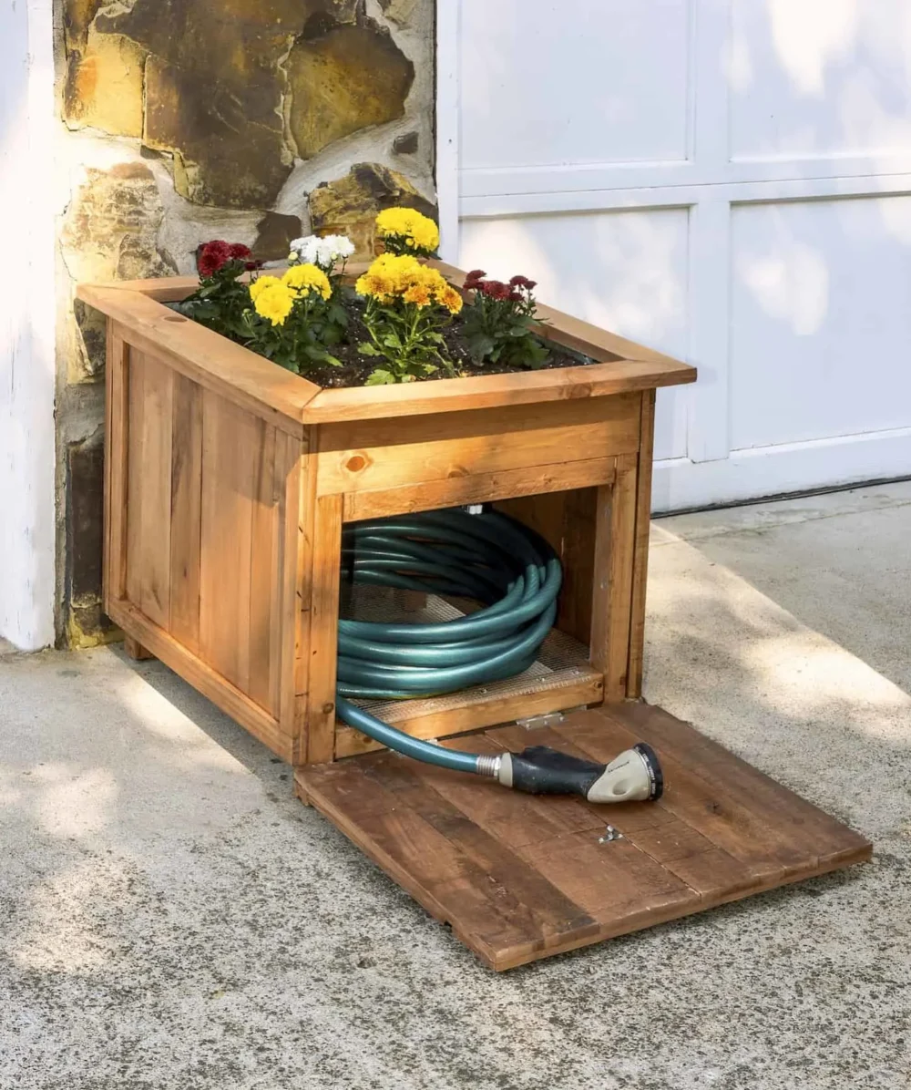 Planter with holder for garden hose 