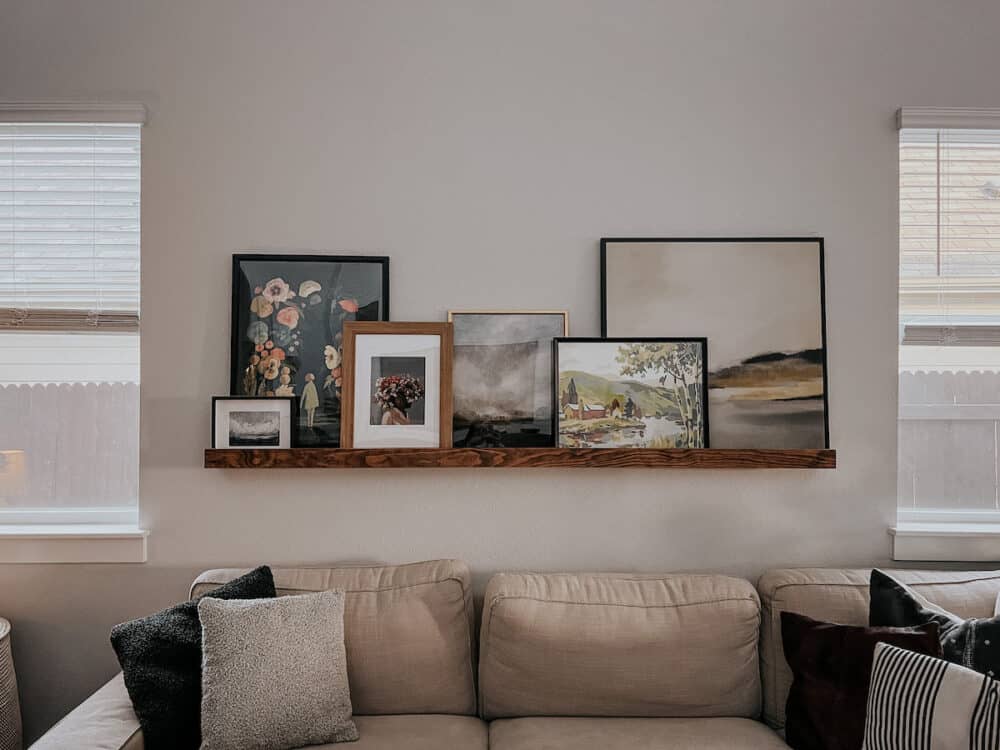 living room with an art ledge full of art 