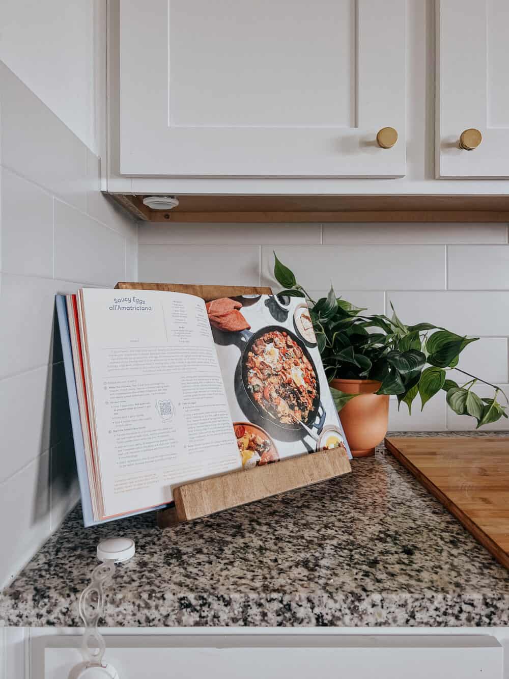 corner of a kitchen with a cookbook sitting open on a DIY cookbook stand 