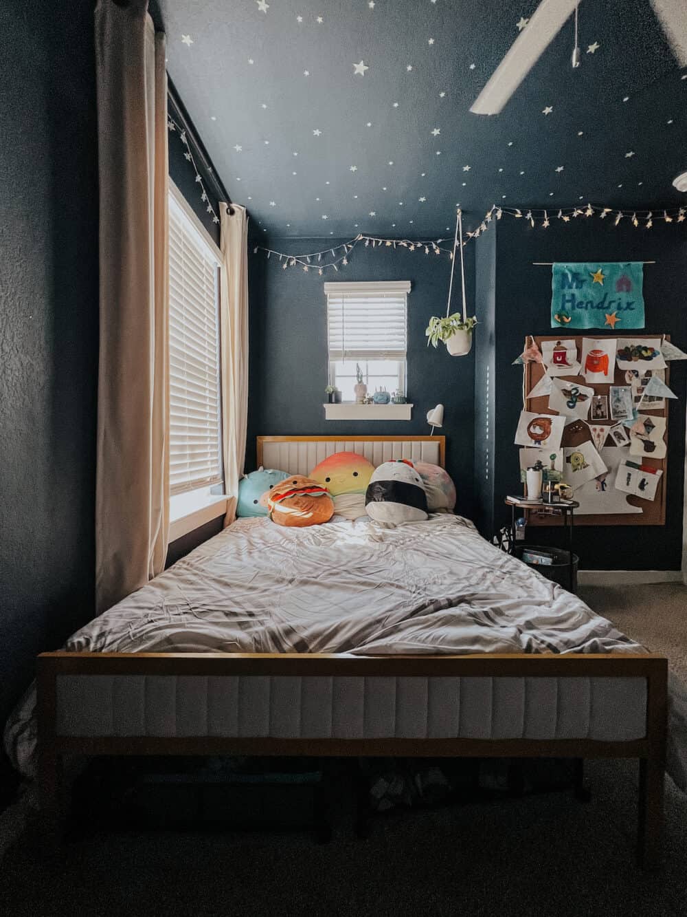 dark blue kid room with a full sized upholstered bed 