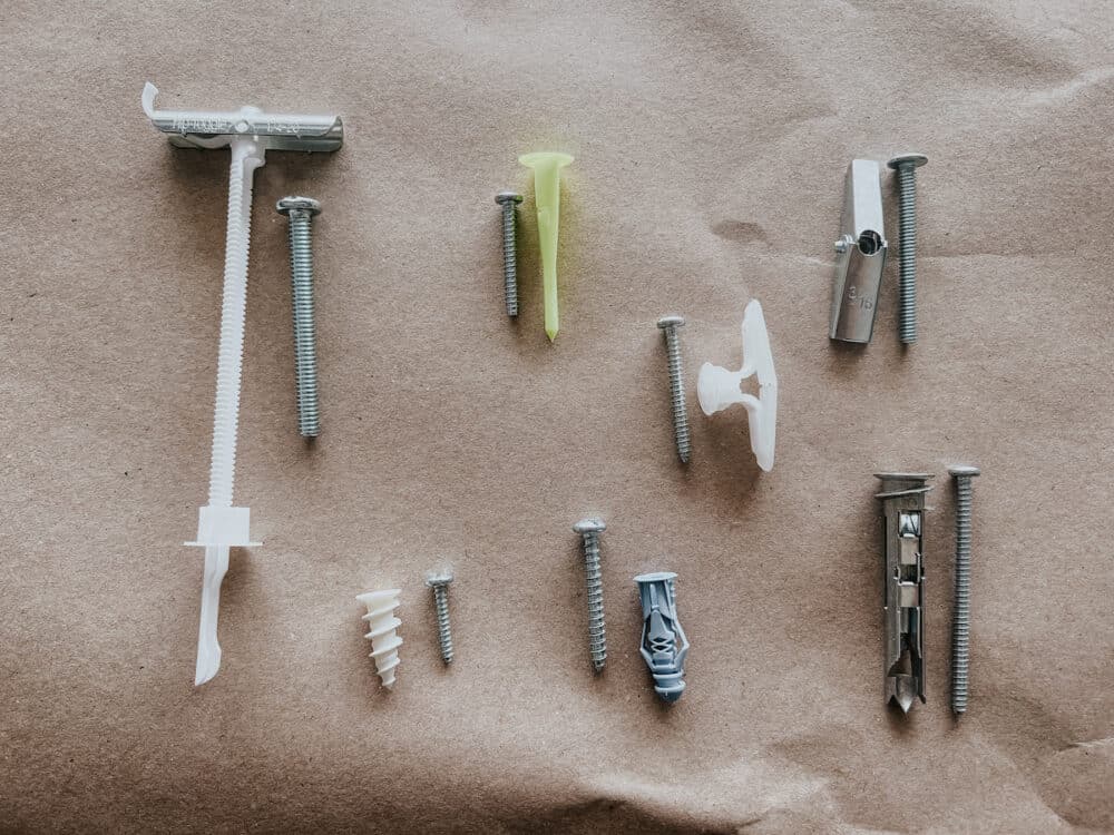 collection of 7 different drywall anchors 