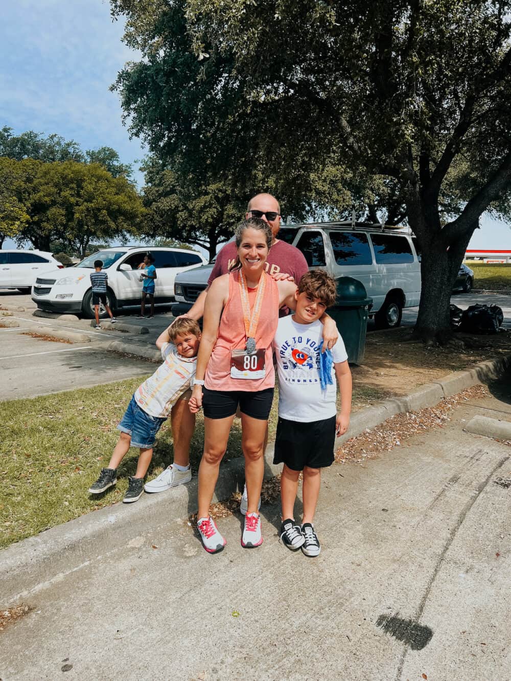 woman posing with her family after running a marathon