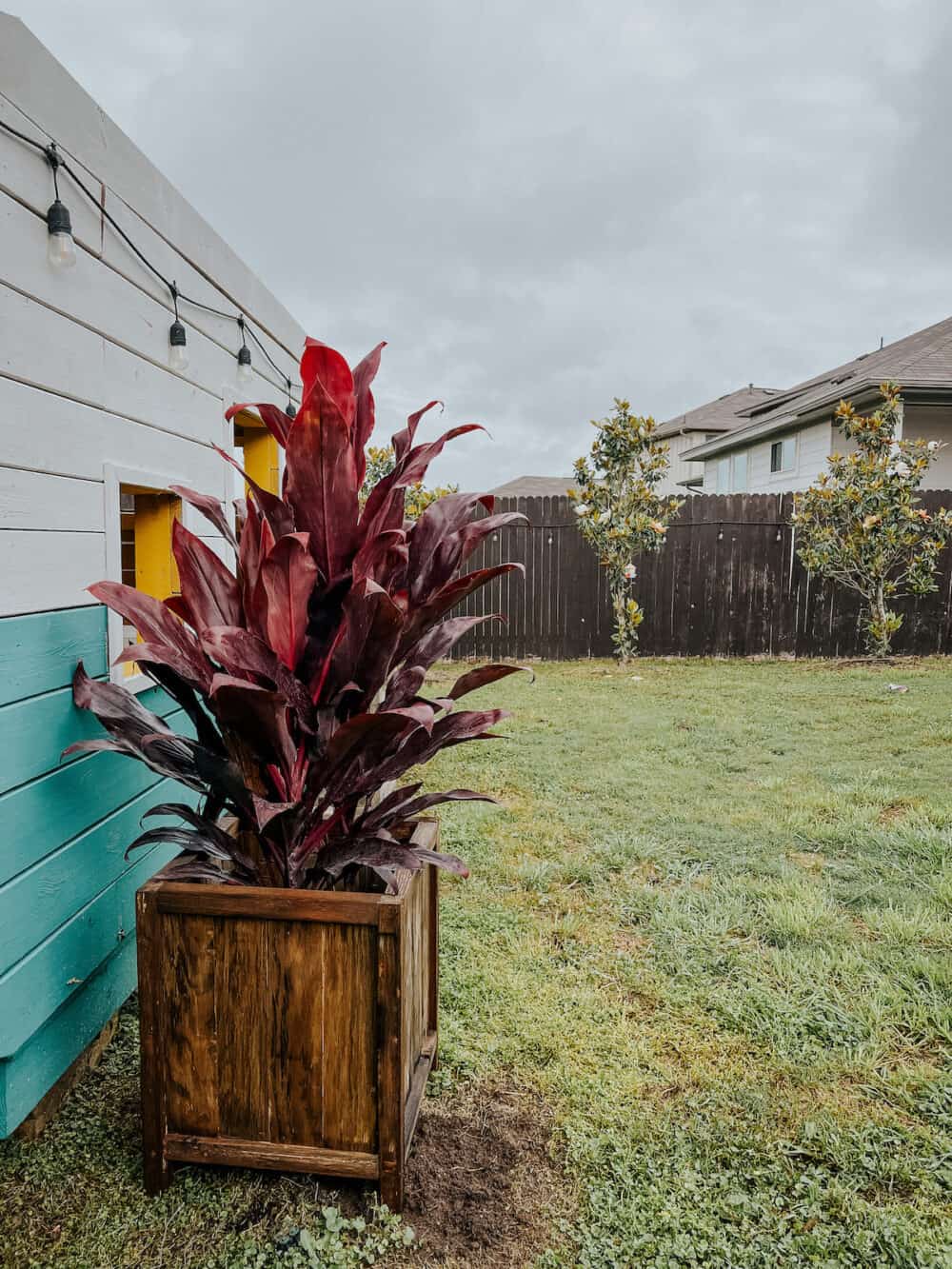 DIY outdoor planter box sitting in a backyard space 
