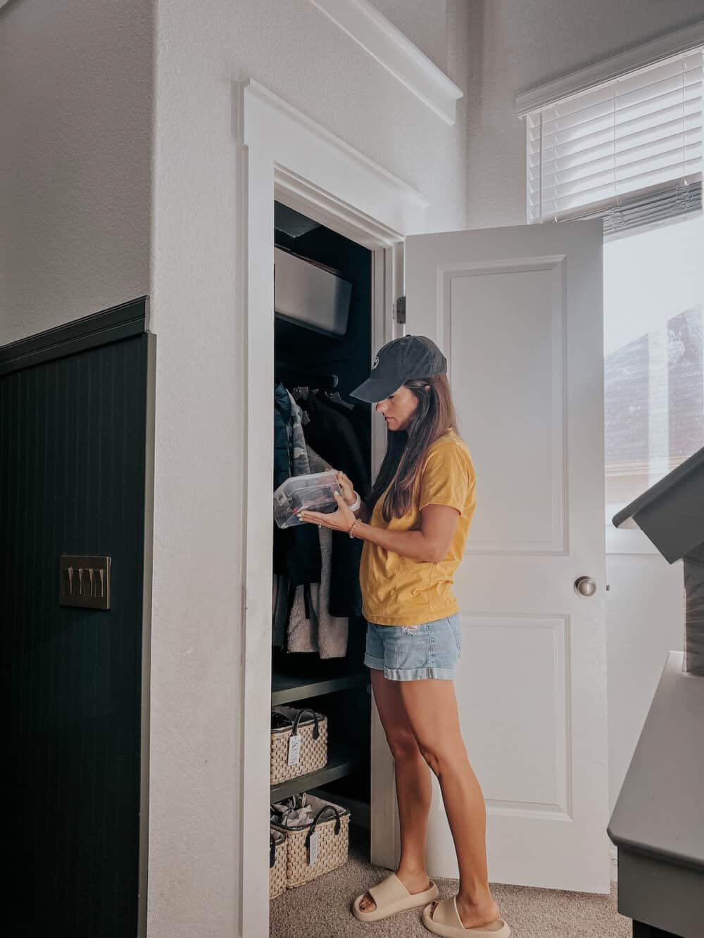 woman standing in front of an organized coat closet 