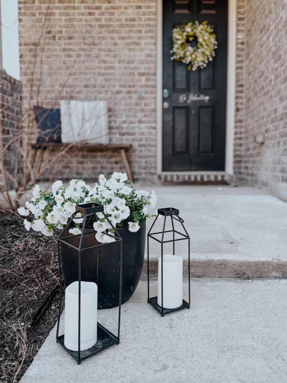 front steps with metal lanterns and white faux flowers
