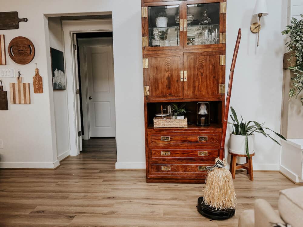 a diy broom halloween decoration attached to a robot vacuum