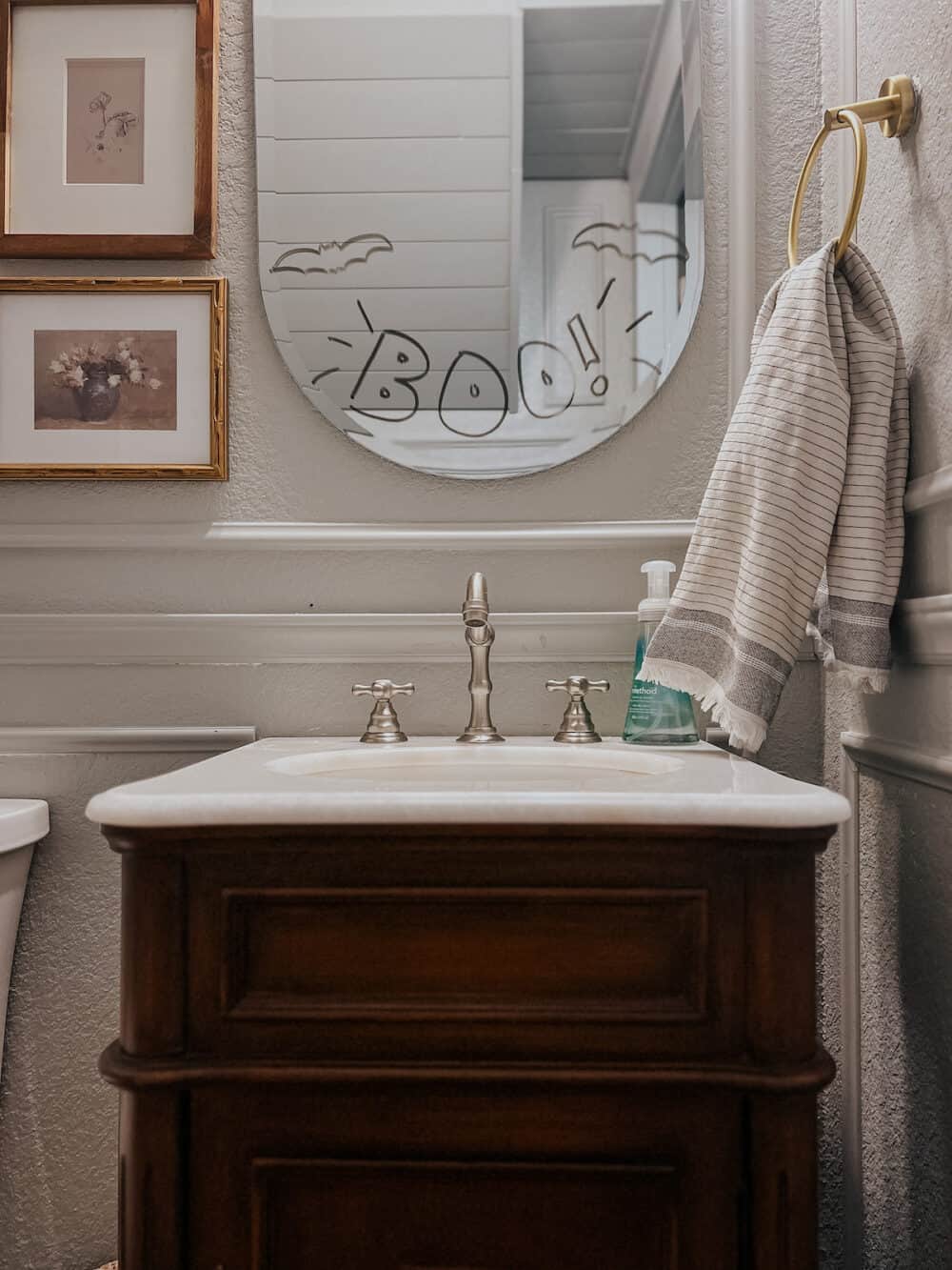 powder room with a halloween drawing on the mirror 