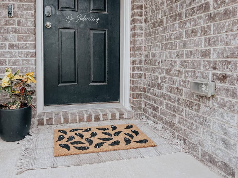 Front porch with Halloween themed door mat