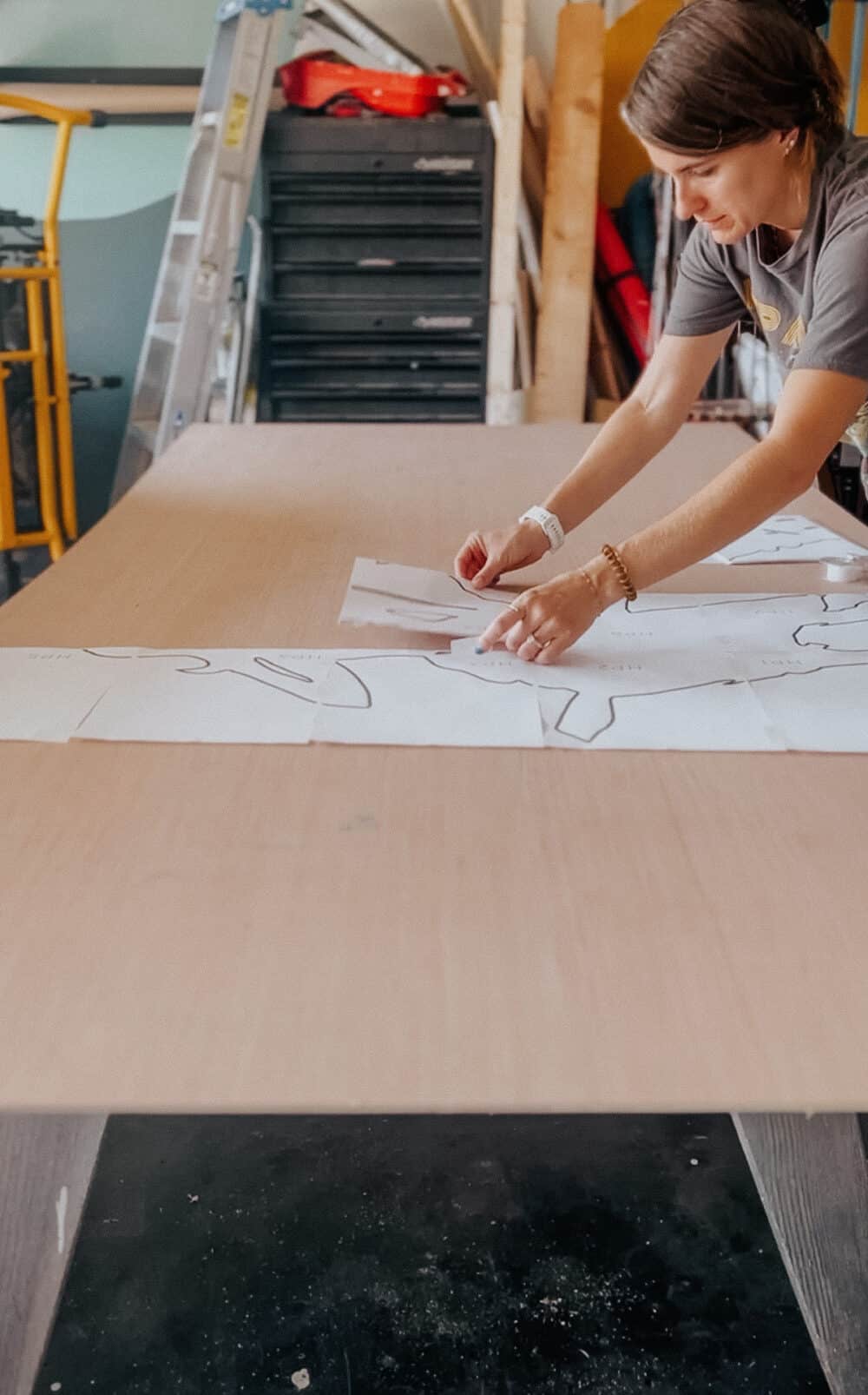 woman laying out a template to create a DIY halloween silhouette of the sanderson sisters 