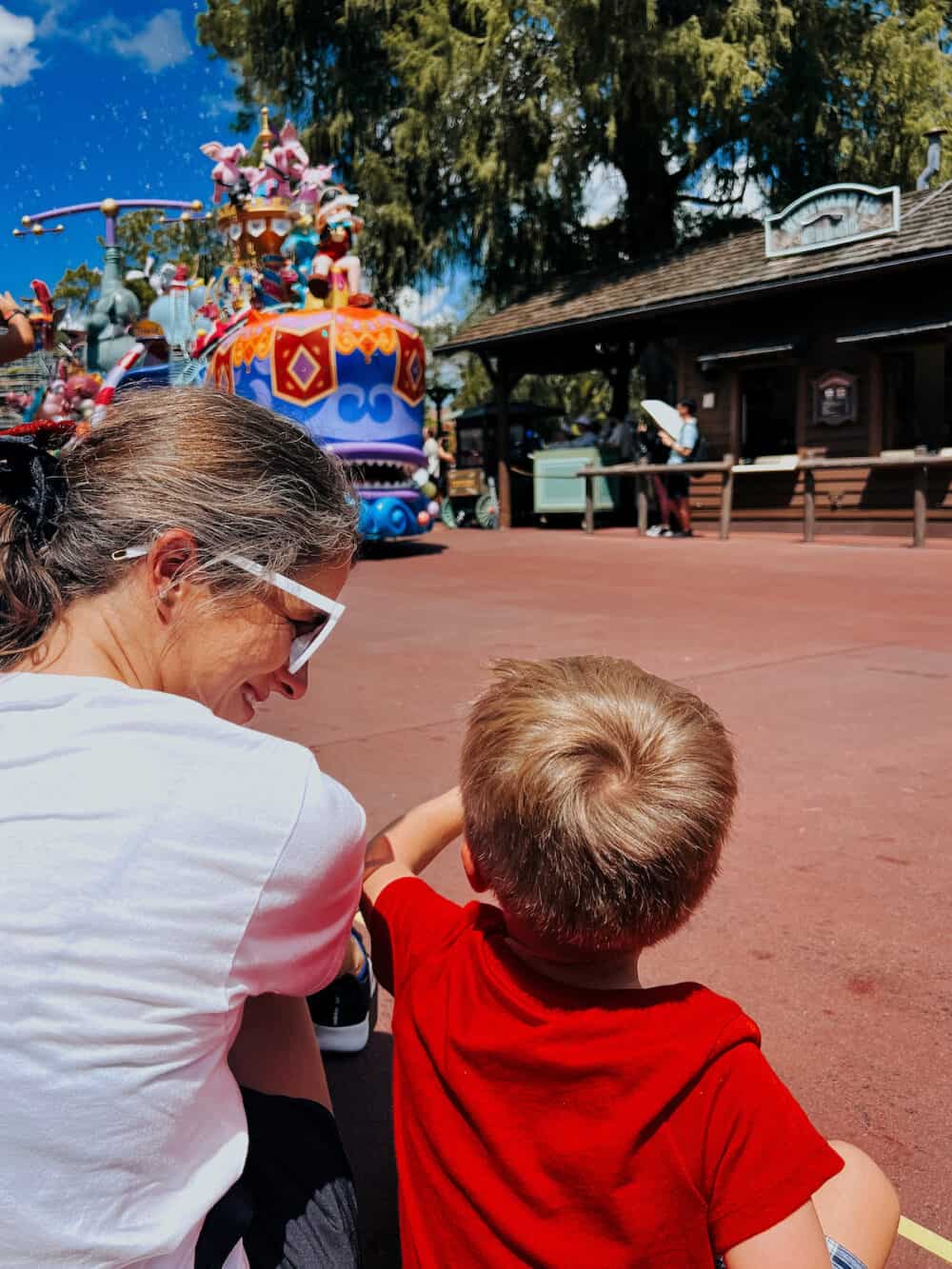 mother and son watching Magic Kingdom parade in Disney WOrld 