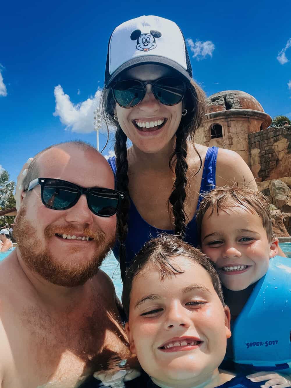 family smiling at a disney world hotel pool 